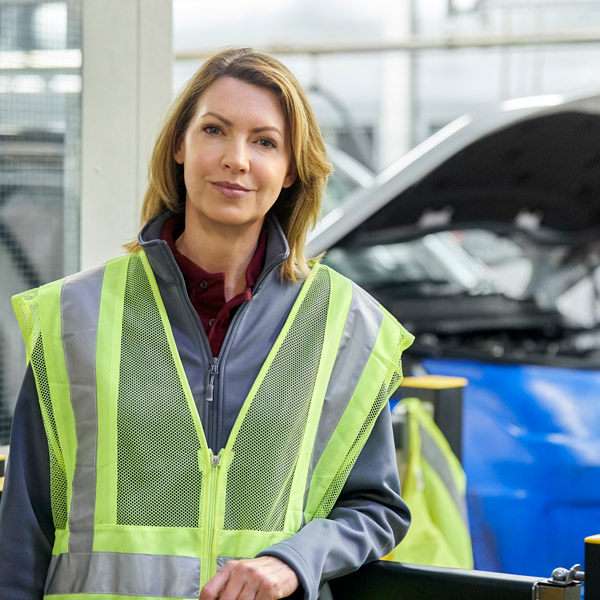 female worker standing in front of car